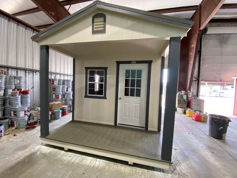 10x16 Stor-Mor cabin in Navajo White with dark gray trim, a 9-lite door and a charcoal metal roof