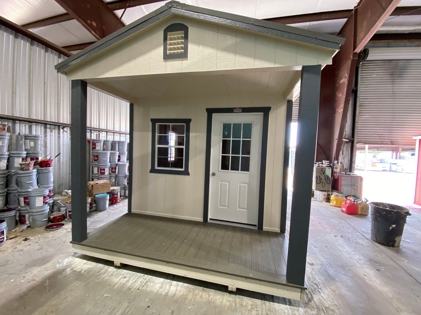 10x16 Stor-Mor cabin in Navajo White with dark gray trim, a 9-lite door and a charcoal metal roof