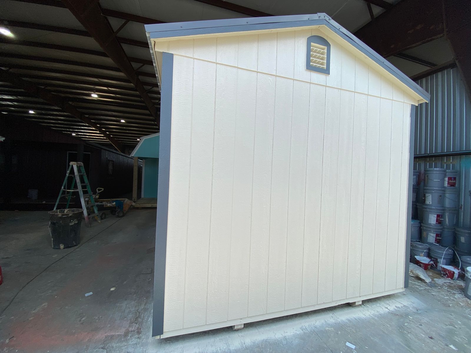 Rear gable end of the 10x16 Navajo White cabin with a vent, dark gray corner trim and eaves