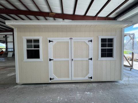 10x16 Stor-Mor Cottage Shed in Navajo White with white trim, double shop doors between two windows and a white metal roof