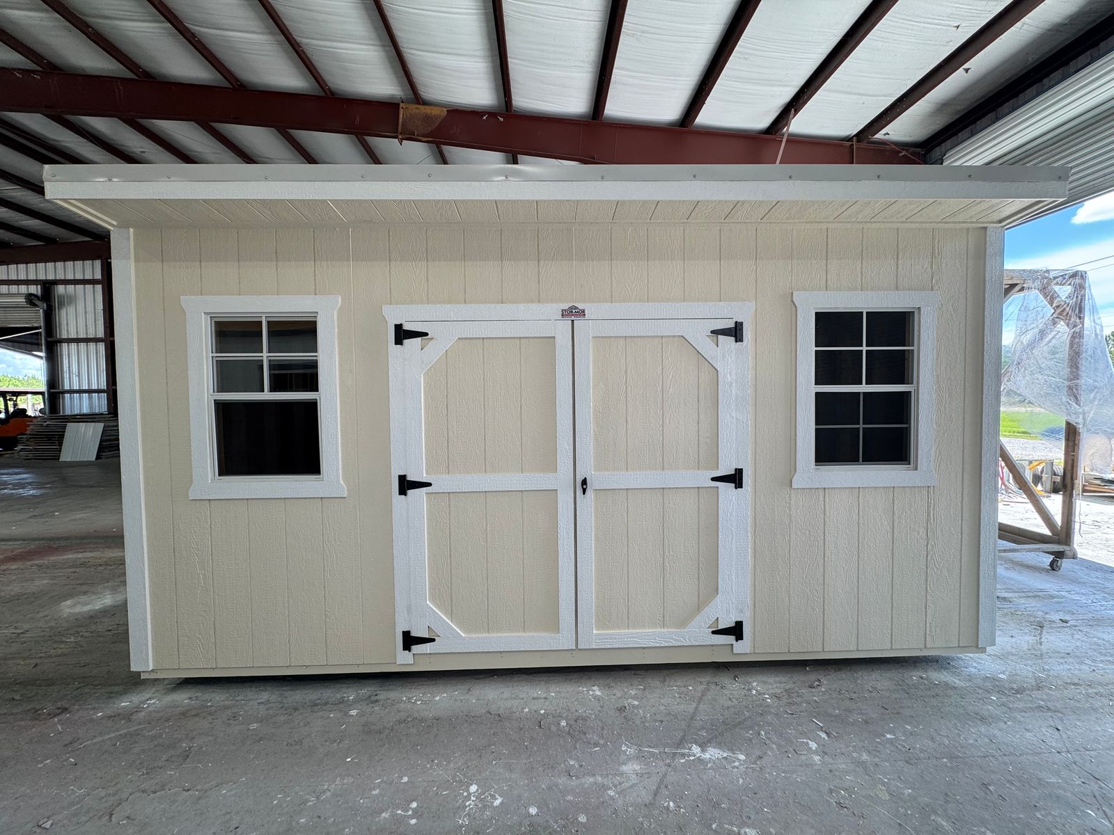 10x16 Stor-Mor Cottage Shed in Navajo White with white trim, double shop doors between two windows and a white metal roof