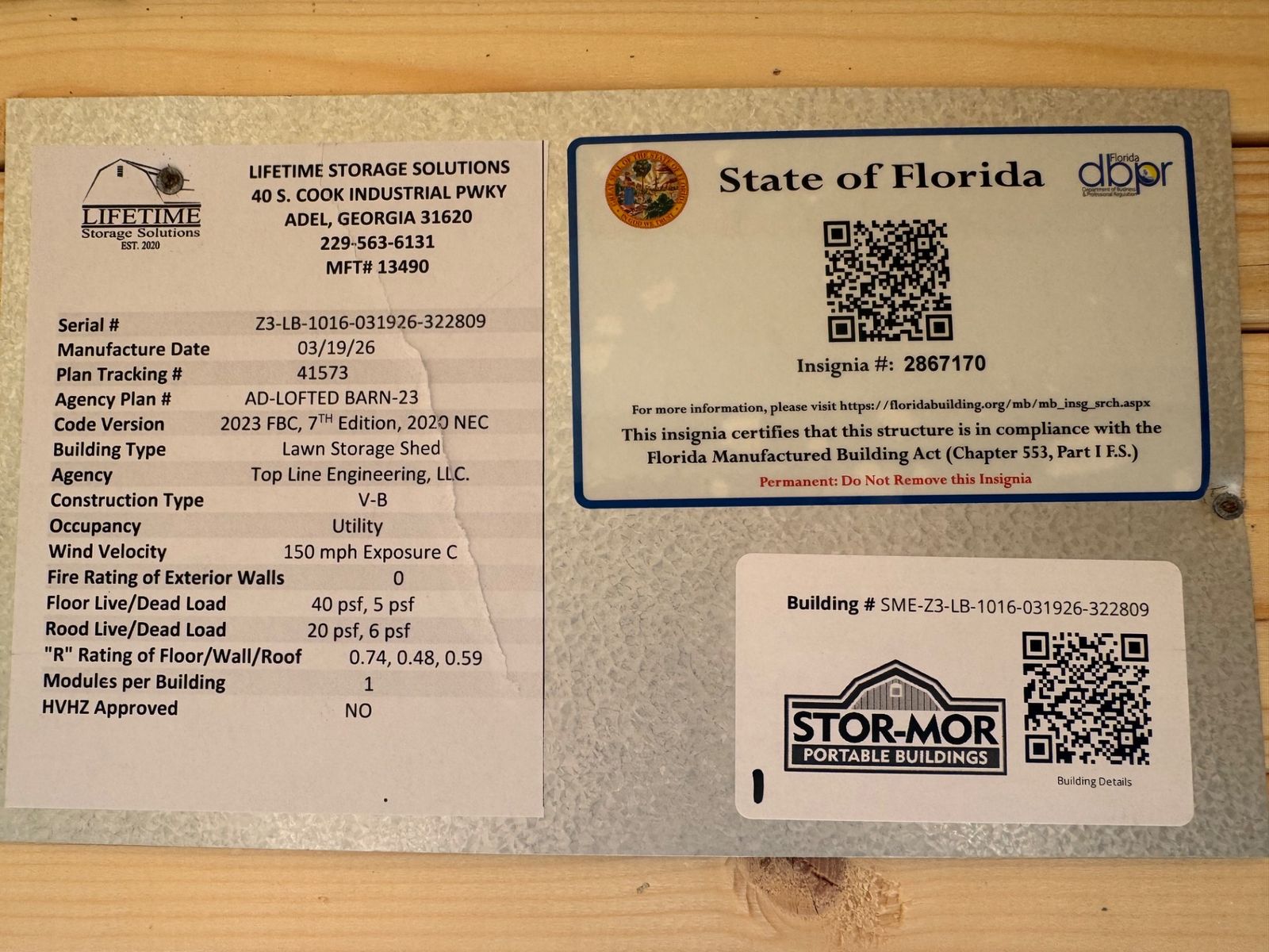 10x16 Belmont Blue Lofted Barn data plate with the State of Florida insignia and QR codes
