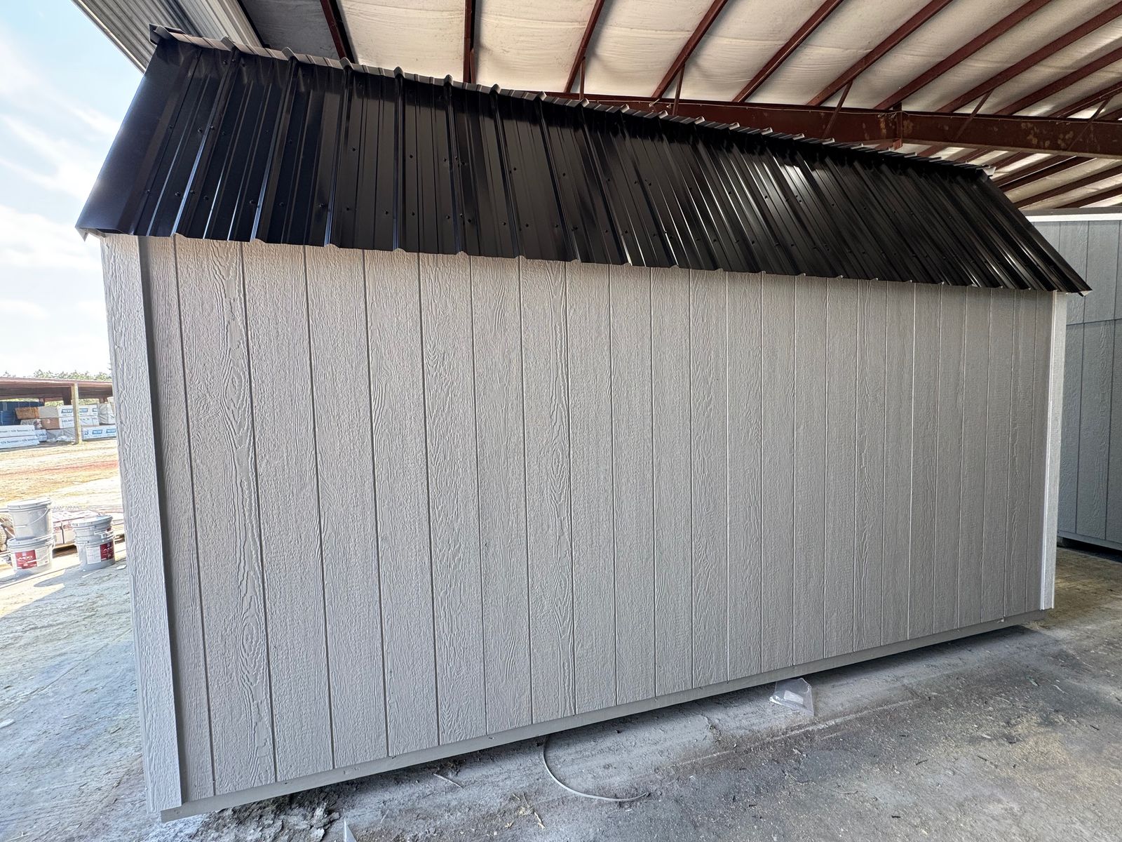Rear long wall of the 10x16 Light Gray Side Lofted Barn under the black metal roof