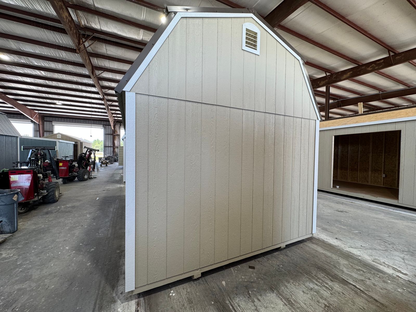 Gable end of the 10x16 New Holland Beige Side Lofted Barn with a vent and white corner trim
