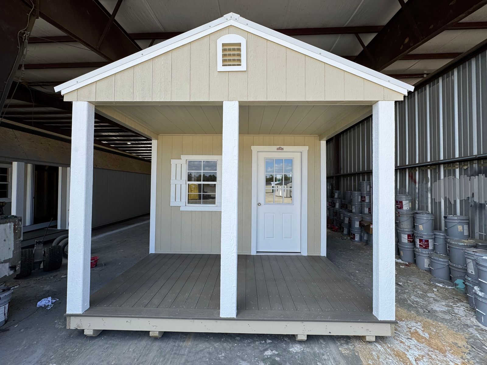 12x24 Stor-Mor cabin in New Holland Beige with white trim, shutters and a white metal roof