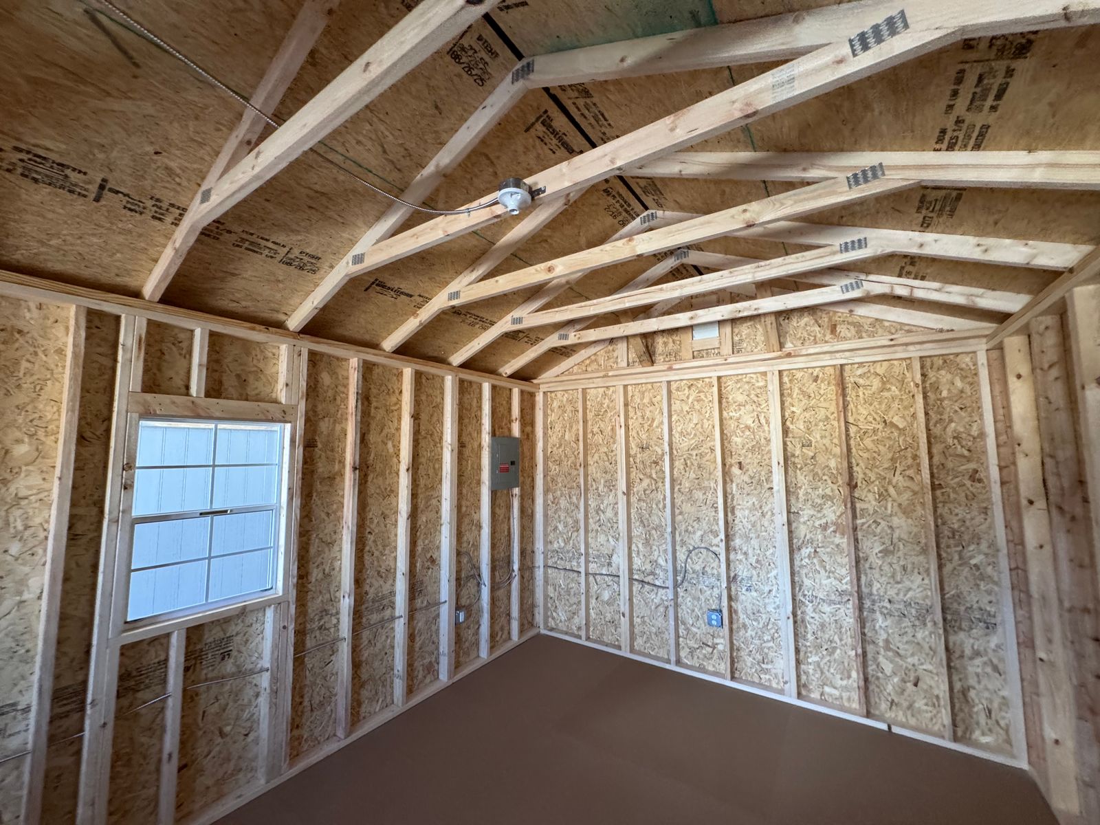 12x24 New Holland Beige Stor-Mor cabin interior, open framing with window and electrical panel