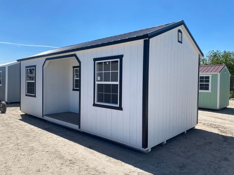 12x24 Stor-Mor Center Cabin in white with black trim, a centered porch and a charcoal metal roof