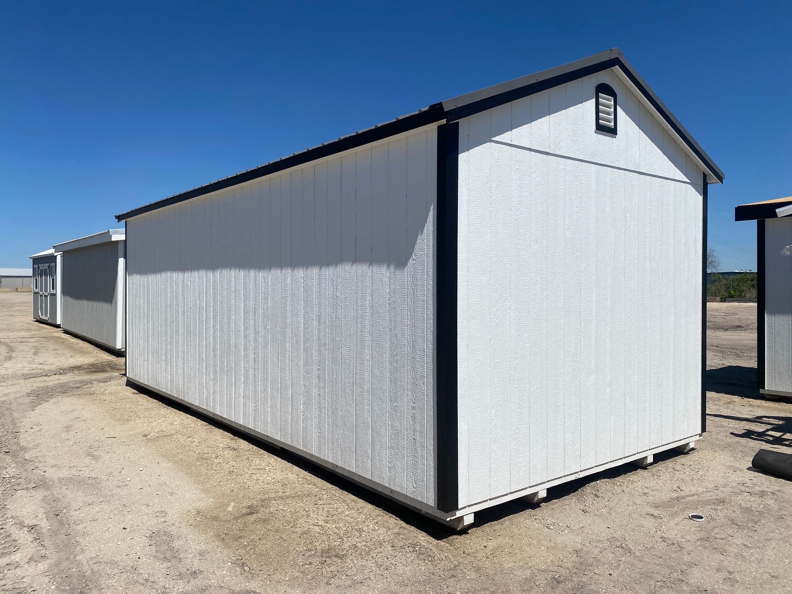 12x24 white Stor-Mor Center Cabin, rear corner view with black trim and gable vent
