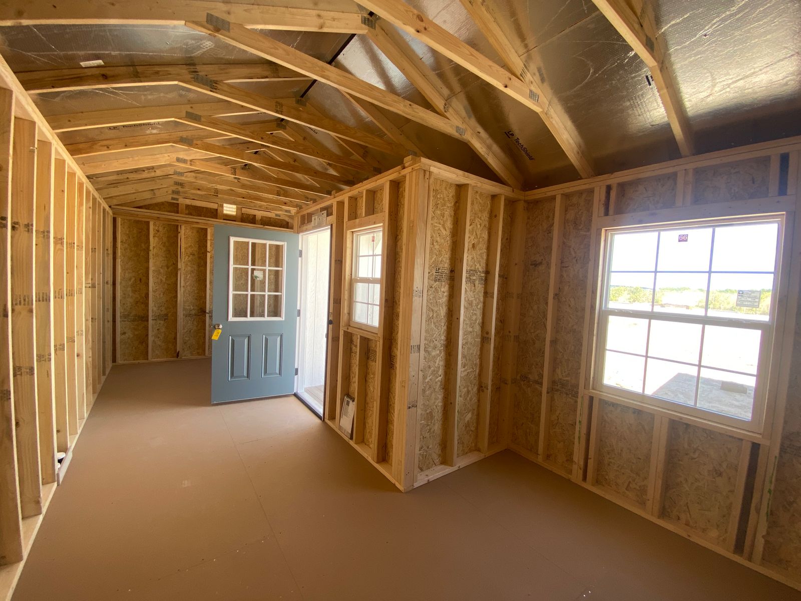12x24 white Stor-Mor Center Cabin interior with blue 9-lite door and thermal windows