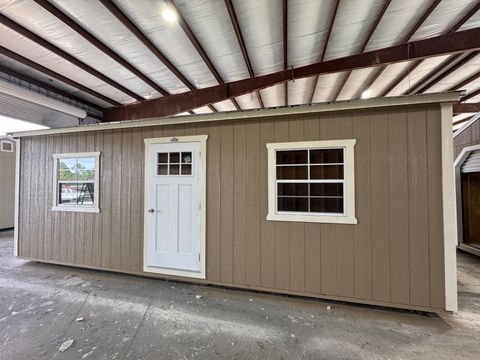 12x24 Stor-Mor garage in Buckskin with Navajo White trim, a roll-up garage door and a Burnished Slate metal roof