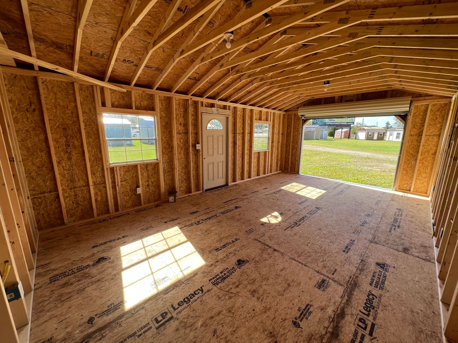 14x24 Dark Gray Stor-Mor garage interior facing the open roll-up door, with window and entry door