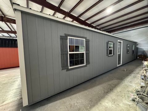 16x44 Stor-Mor Side Utility workshop in Cape Cod Gray with white trim, dark gray door and shutters, and a charcoal metal roof