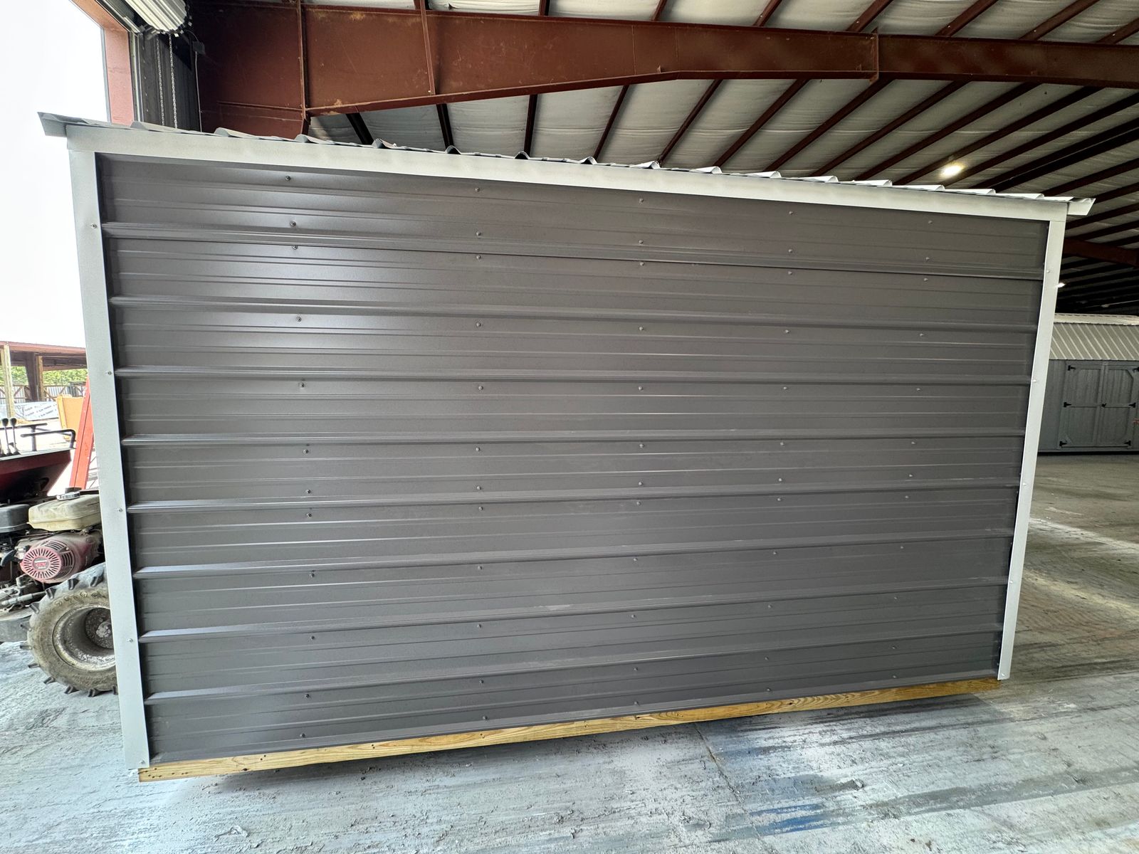 8x12 Stor-Mor Metal Utility in charcoal, long side wall with white trim and white metal roof