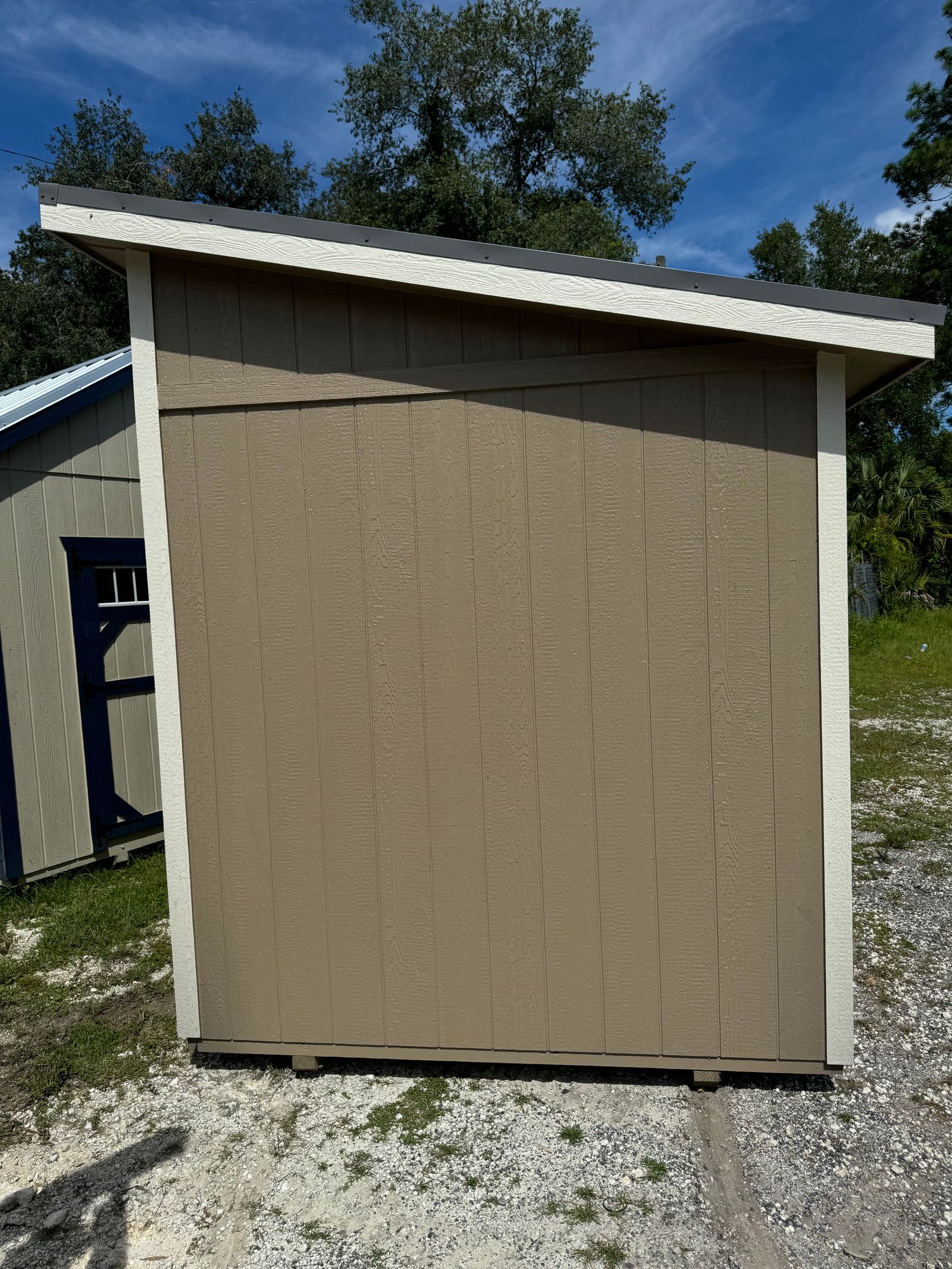 Side wall of the 8x12 Buckskin Studio showing the sloped roofline and Navajo White trim